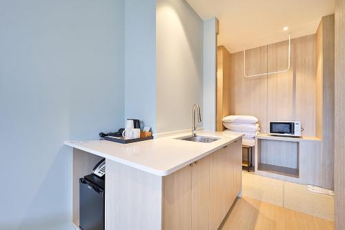a small kitchen with a sink and a microwave at Browndot Signature Hotel in Yongjae