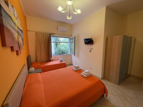 an orange room with two beds and a window at Edeler House in Pula