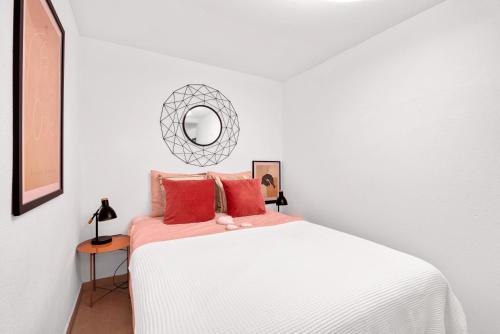 una camera da letto con un letto bianco con cuscini rossi e uno specchio di Appartment Patricia a Orba