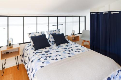 Un dormitorio con una cama grande con cortinas azules. en Maison Aranea, en Ascain