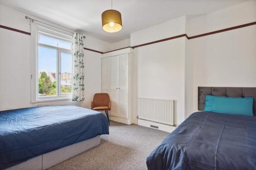 1 dormitorio con cama y ventana en Cozy Stay Rooms, en Raynes Park