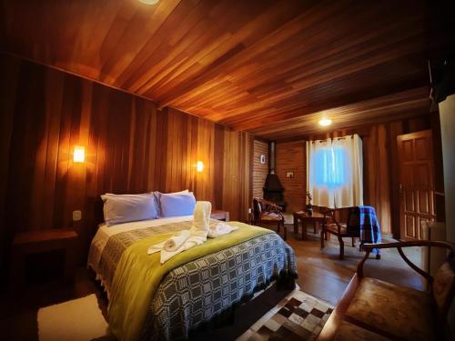a bedroom with a bed with towels on it at Pousada Sotaque Mineiro in Cunha