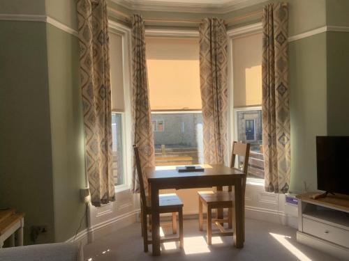 a dining room with a table and chairs and a window at Spacious and bright 1 - bedroom rental unit in Ilkley