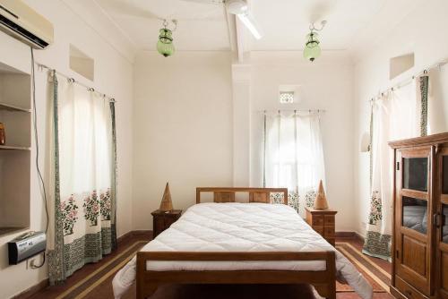 a bedroom with a bed and two windows at Kawa Guest House in Jaipur
