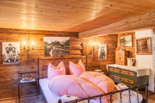 a bedroom with a bed in a room with wooden walls at Stoffelhäusl in Reith im Alpbachtal