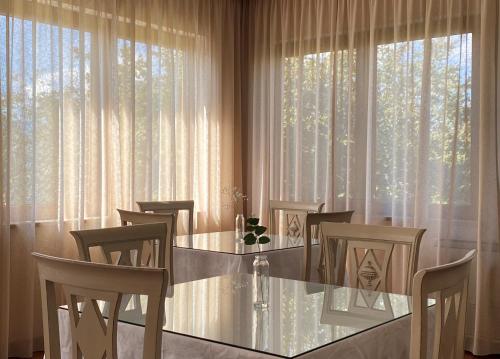 a dining room with a table and chairs in front of a window at Hotel SJ in Tondela