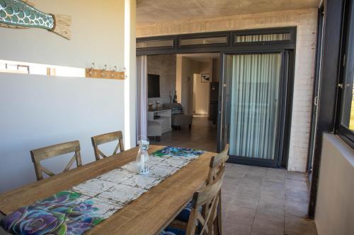 a dining room with a wooden table and chairs at 33D Kabeljauws Beach in Jeffreys Bay