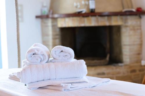 a stack of towels on a table with a fireplace at Kalomoira's Apartments in Elafonisos