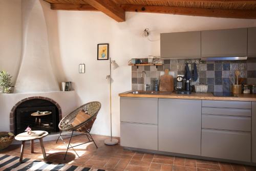a kitchen with a fireplace and a table and a chair at Três Figos in São Luis