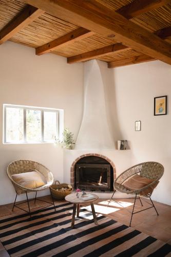 a living room with two chairs and a fireplace at Três Figos in São Luis