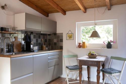 a kitchen with white cabinets and a table and chairs at Três Figos in São Luis