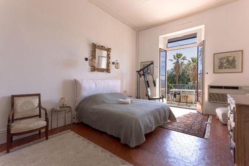 une chambre avec un lit, une chaise et une fenêtre dans l'établissement Le Château Vallombrosa by Halldis, à Cannes