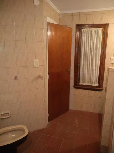 a bathroom with a toilet and a shower with a door at Nono Angelo 3° in San Pedro