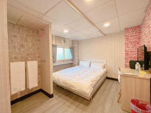台北的住宿－新獅城商務旅店New Lion City Hotel，一间卧室设有一张床和砖墙