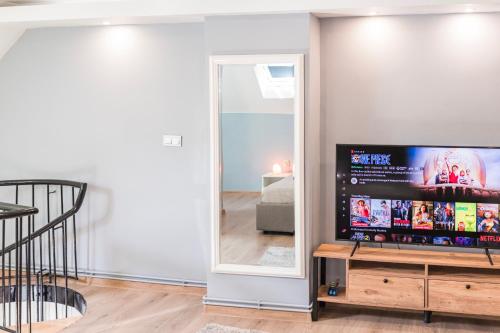 a living room with a television and a mirror at Downtown Apartment Travnik in Travnik
