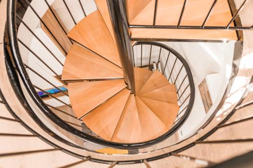 a wooden spiral staircase in a building at Downtown Apartment Travnik in Travnik