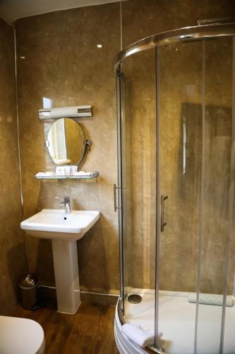 a bathroom with a shower and a sink and a mirror at The Eastbury & Spa in Sherborne