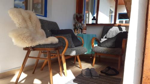 a living room with three chairs and shoes on the floor at Chalupa - Dešov in Desov