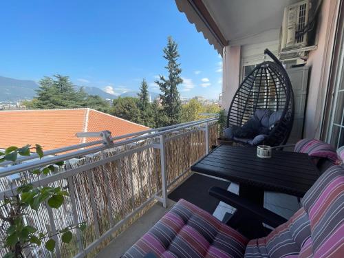 a porch with a table and chairs on a balcony at Pine-Tree Spacious 2 BDR Apartment near Tanners' Bridge with hot tub in Tirana