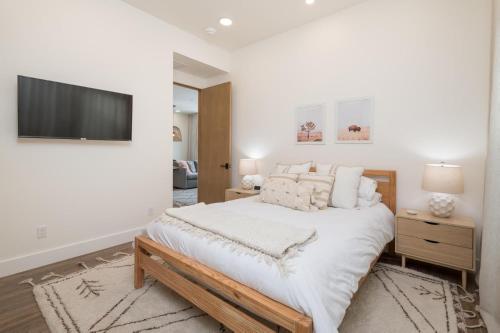 um quarto branco com uma cama grande e uma televisão de ecrã plano em The Lofts 660 #203 em Ketchum