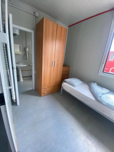 a bedroom with a bed and a cabinet and a sink at Ubytovna SDC in Valcha