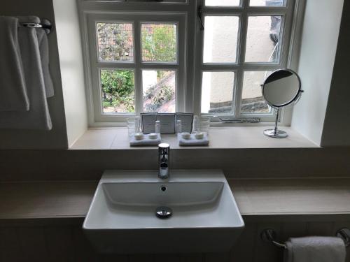 a bathroom sink with a mirror and a window at The Eastbury & Spa in Sherborne