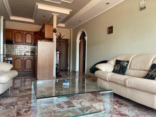 a living room with a couch and a glass table at Pine-Tree Spacious 2 BDR Apartment near Tanners' Bridge with hot tub in Tirana