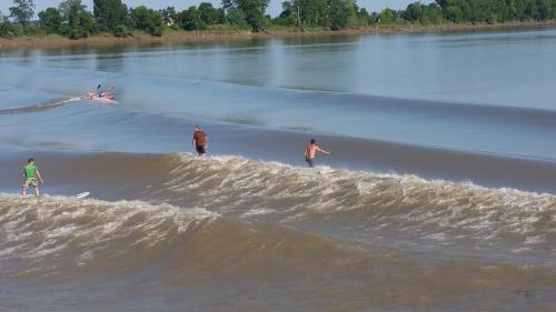 a group of people standing on a wave in the water at Kyriad Libourne Saint Emilion in Arveyres