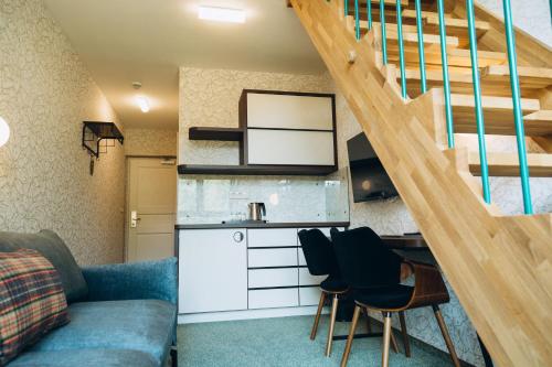 uma sala de estar com um sofá, uma cozinha e escadas em Hotel Vodník em Vimperk