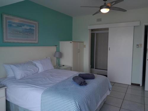 Schlafzimmer mit einem weißen Bett und einem Deckenventilator in der Unterkunft Nomads Nook 7 Sea view 6 Sleeper in Margate