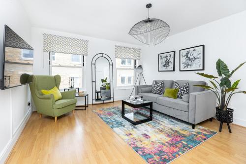 a living room with a couch and a chair at Fantastic 2BR Flat, 3 min Shoreditch High Street in London