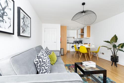a living room with a couch and a table at Fantastic 2BR Flat, 3 min Shoreditch High Street in London