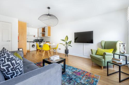 a living room with a couch and a table at Fantastic 2BR Flat, 3 min Shoreditch High Street in London
