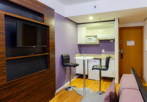 a living room with a couch and a table and chairs at Comfort Suites Alphaville in Barueri