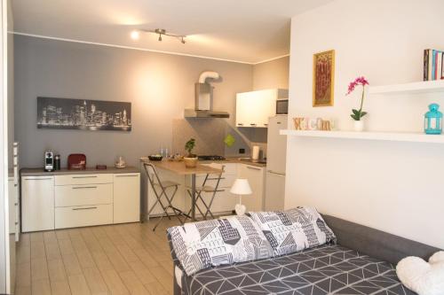 ein Wohnzimmer und eine Küche mit einem Sofa und einem Tisch in der Unterkunft Cimoneight in Varese
