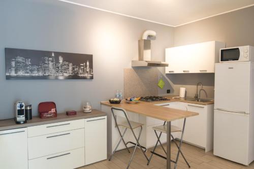 eine Küche mit weißen Schränken und einem Holztisch in der Unterkunft Cimoneight in Varese