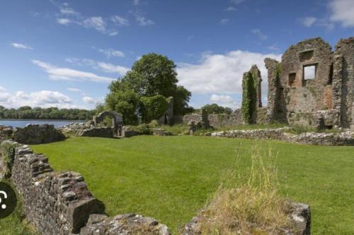Une vieille ruine d'un château avec un champ verdoyant dans l'établissement Lakeland Lodge, à Derrylin