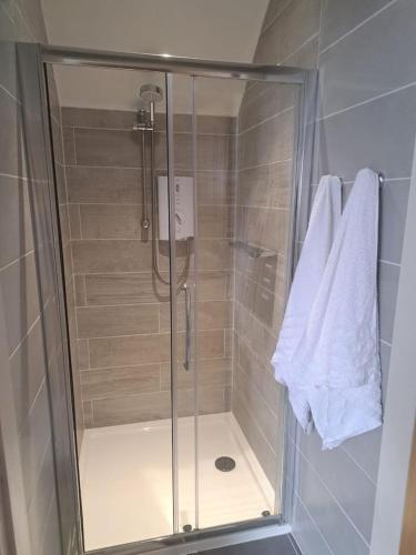 a shower with a glass door in a bathroom at Lakeland Lodge in Derrylin