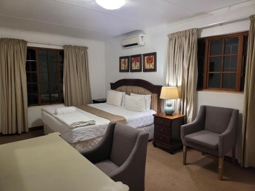 a hotel room with a bed and a chair at 147@ Simon Bekker Kosmos in Hartbeespoort