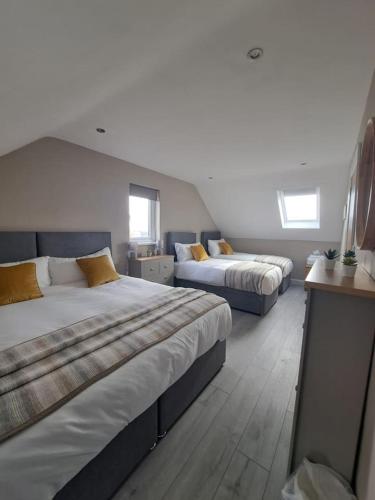 a bedroom with two beds and two windows at Lakeland Lodge in Derrylin