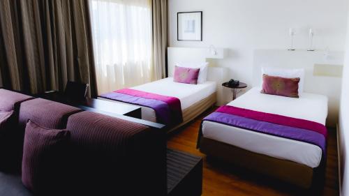 a hotel room with two beds and a window at Comfort Suites Alphaville in Barueri