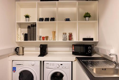 a kitchen with a washer and dryer and a sink at REZz Dublin in Dublin