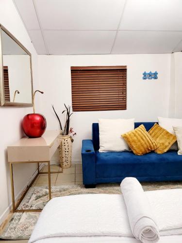 a living room with a blue couch and a mirror at 147@ Simon Bekker Kosmos in Hartbeespoort