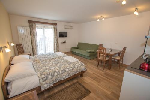a bedroom with a bed and a couch and a table at Tourist farm Megušar in Škofja Loka