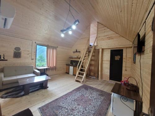 una sala de estar con una escalera en una casa de madera en Guest cottage - Nanka's house en Batumi