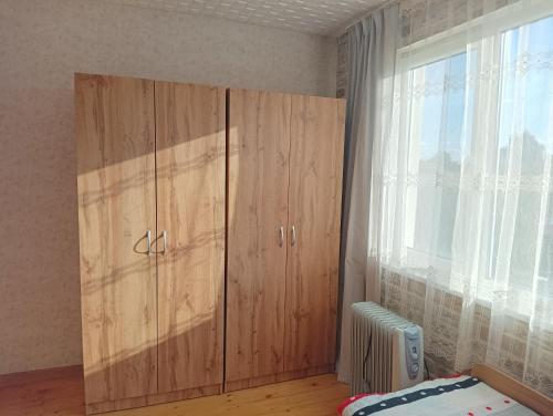 a bedroom with wooden cabinets and a window at 2-ра двойна стая in Dragoman