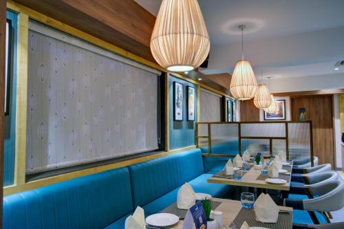 a dining room with tables and chairs and lights at Cozzet Victoria Hotel in Bhubaneshwar