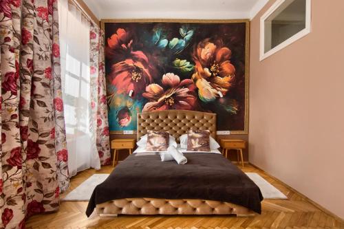 a bedroom with a painting of flowers on the wall at Mikołajska 5 Apartments in Krakow