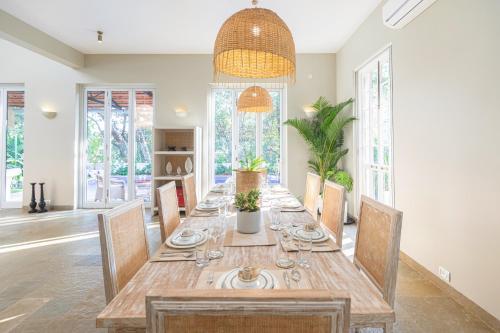 a dining room with a long wooden table and chairs at LohonoStays Colina Villa E in Vagator