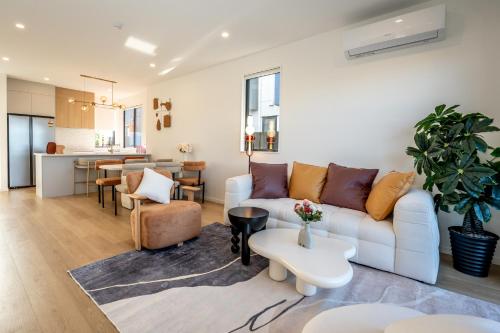 uma sala de estar com um sofá e uma mesa em Charming Urban Townhouse Getaway em Auckland